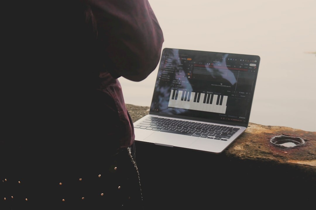 Hands typing on laptop in studio environment